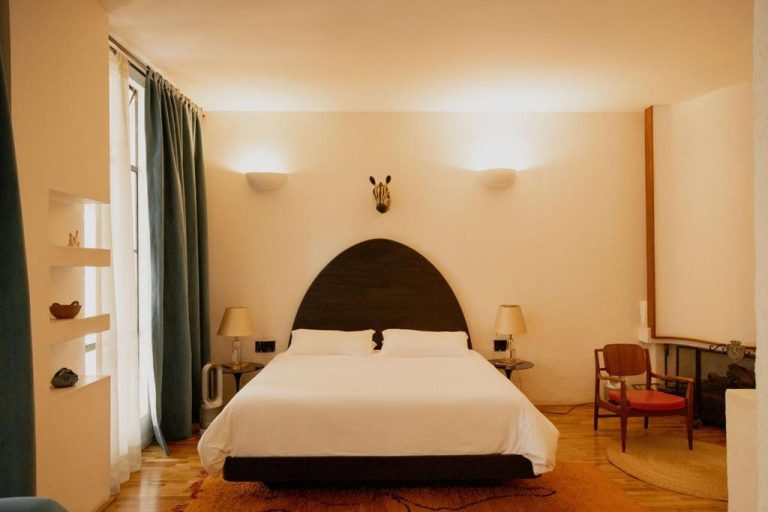 Habitación doble con cabecero en arco oscuro y decoración safari en Casa Pani