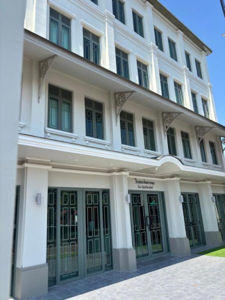 Fachada exterior de estilo colonial del TUAN Hotel Bangkok cerca de Wat Arun con puertas verdes