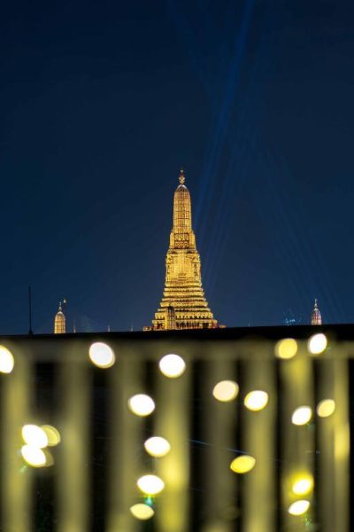 Vista nocturna del templo Wat Arun iluminado desde el TUAN Hotel Bangkok con luces bokeh