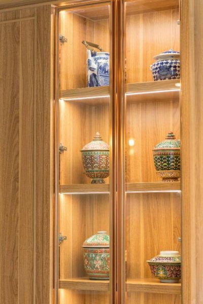 Vitrina de madera iluminada con colección de porcelana china decorativa en TUAN Hotel Bangkok near Wat Arun