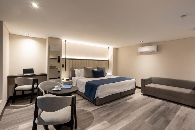 Habitación deluxe con cama doble, sofá y zona de trabajo en Altus Hotel
