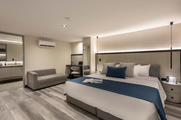 Habitación deluxe con cama king size y decoración moderna en tonos azules del Altus Hotel
