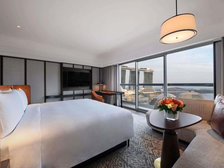 Habitación de lujo con cama king y vistas panorámicas a Marina Bay Sands en Fairmont Singapore