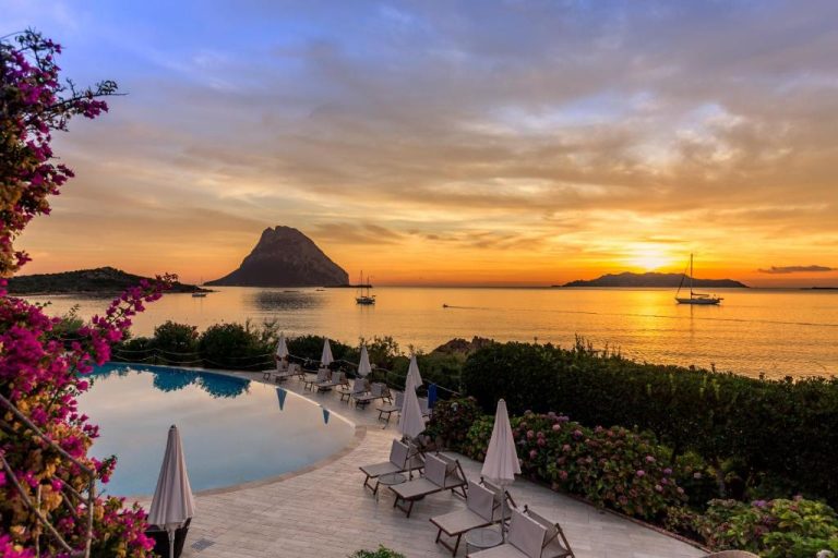 Piscina infinita del Hotel Don Diego con vistas al mar y espectacular puesta de sol sobre islote rocoso