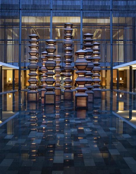 Lobby con esculturas tradicionales balinesas y estanque reflectante en The Anvaya Beach Resort Bali