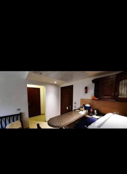 Cocina y comedor interior de la Aldahabeya Village con encimera de granito y armarios de madera oscura