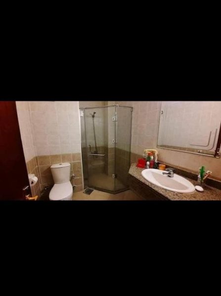 Baño completo con ducha de cristal, inodoro y lavabo en el hotel قريه الدهبيه