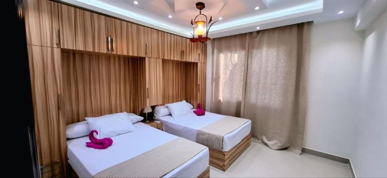Habitación doble con dos camas y cabecero de madera en Luxury Sharm Hills Resort