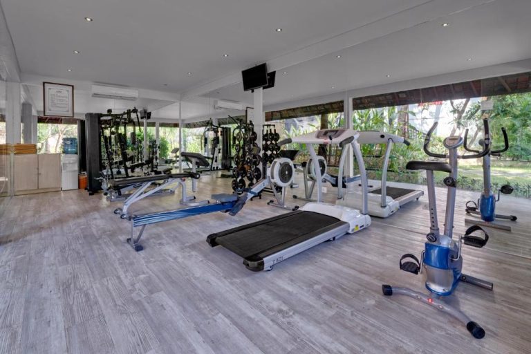 Gimnasio completamente equipado con cintas de correr y máquinas de ejercicio en Bali Garden Beach Resort