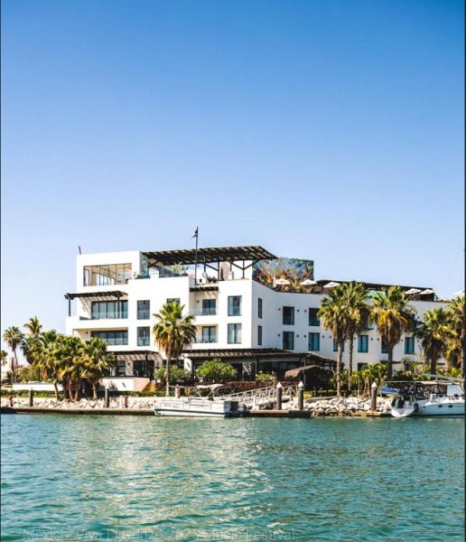 Fachada exterior del Hotel El Ganzo Adults Only visto desde la marina con palmeras y yates