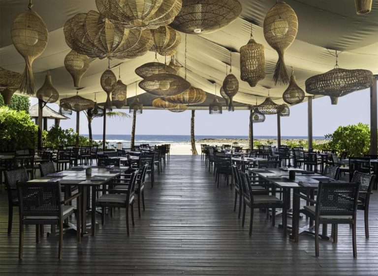 Restaurante terraza frente al mar con lámparas de ratán en The Apurva Kempinski Bali