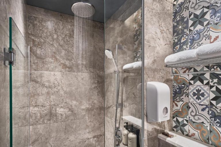 Ducha de lluvia con azulejos de mármol y cristal en el Mercure ICON Singapore City Centre