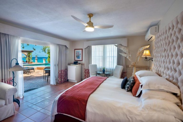 Habitación de lujo con cama doble y vistas a la piscina y al mar en Little Arches Boutique Hotel