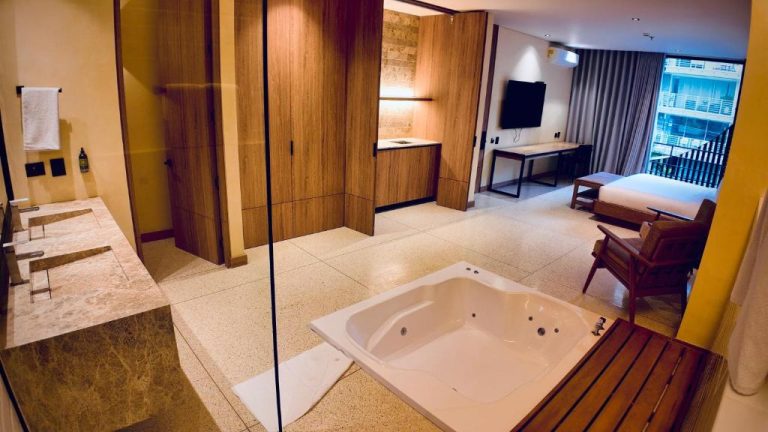 Suite de lujo con jacuzzi empotrado y baño abierto al dormitorio en el Iconik Hotel