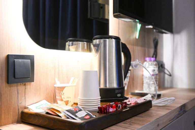 Rincón de café y té con hervidor eléctrico, tazas y Nescafé en habitación del Nas Corner Hotel