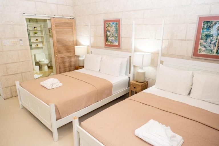 Habitación doble con dos camas y baño privado en Sweetfield Manor, decoración luminosa y elegante