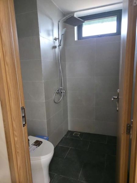 Baño moderno con ducha de lluvia y aseo en el Huỳnh Nga Măng Đen Hotel