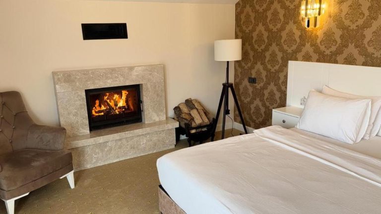 Habitación de lujo con chimenea encendida y cama doble en Green Roof Boutique Hotel Istanbul Airport