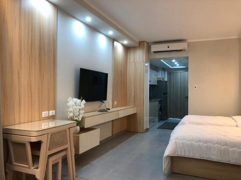 Habitación suite moderna con TV, escritorio y cocina integrada en Hotel y Resort Skandic