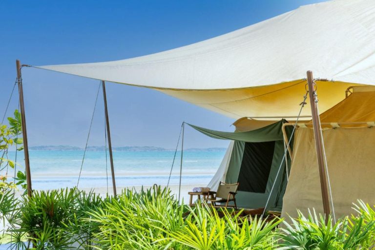 Tienda de glamping con toldo y vistas al mar turquesa en Camp Cayla Coasta