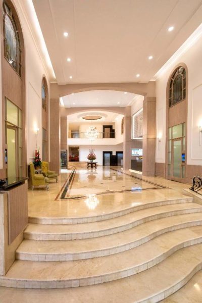 Lujoso lobby con escaleras de mármol y arcos elegantes del Hotel Dann Carlton Medellín