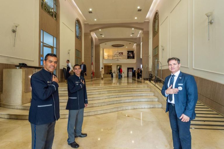 Personal de recepción en el elegante lobby del Hotel Dann Carlton Medellín con escalinatas de mármol