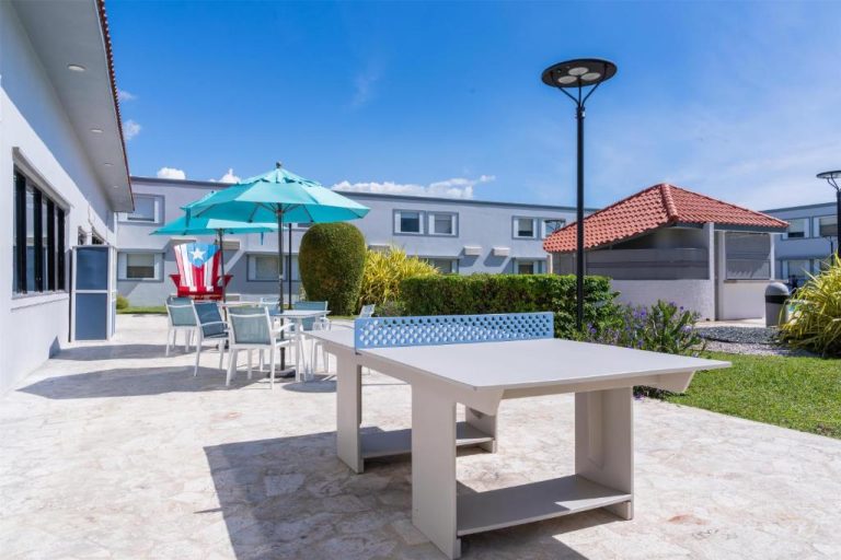 Terraza exterior con mesa de ping pong y sombrillas del Spark by Hilton Ponce en Puerto Rico