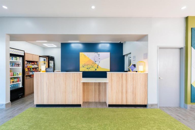 Recepción moderna del Spark by Hilton Ponce con tienda de snacks y decoración en azul y verde