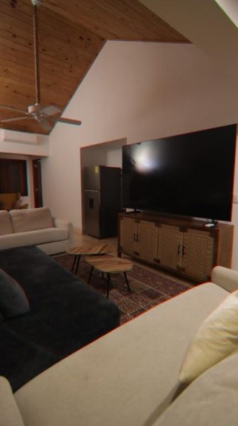 Sala de estar con televisor grande y sofás del Selectum Hacienda Punta Cana con techo de madera
