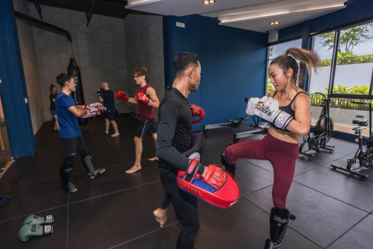 Clase de Muay Thai en el gimnasio del HOMA Phuket Town con entrenador y participantes practicando boxeo