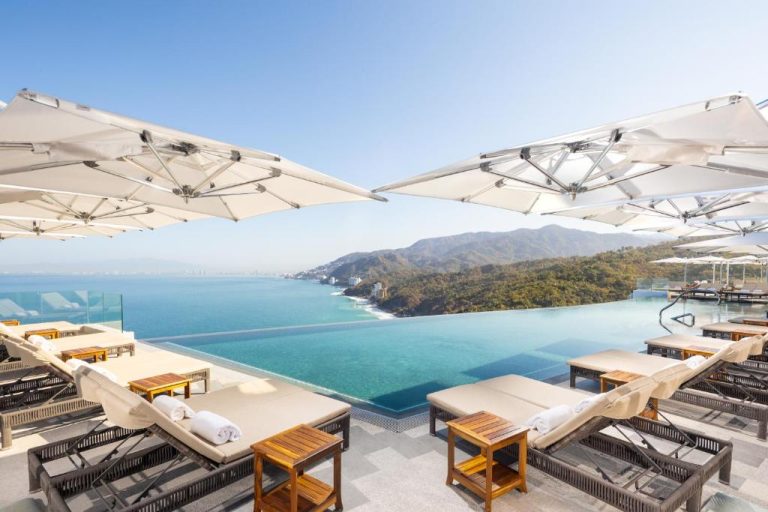 Piscina infinita con tumbonas y vistas al océano y montañas en Garza Blanca Sanctuary Puerto Vallarta