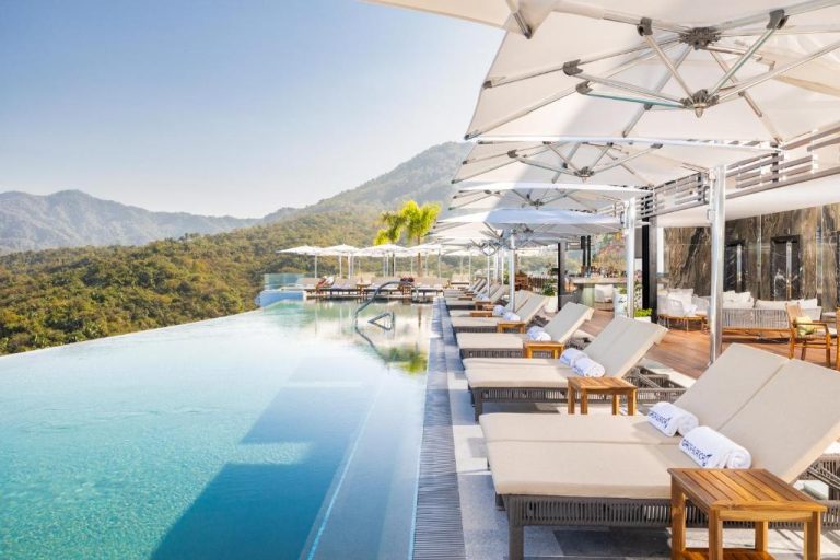 Piscina infinita con tumbonas y sombrillas blancas del Garza Blanca Sanctuary Puerto Vallarta