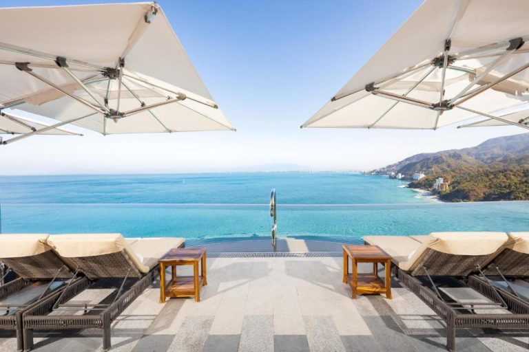 Piscina infinita con tumbonas y vistas al mar turquesa en Garza Blanca Sanctuary Puerto Vallarta