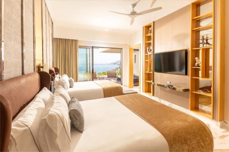 Habitación doble con dos camas y vista al mar desde balcón en Garza Blanca Sanctuary Puerto Vallarta