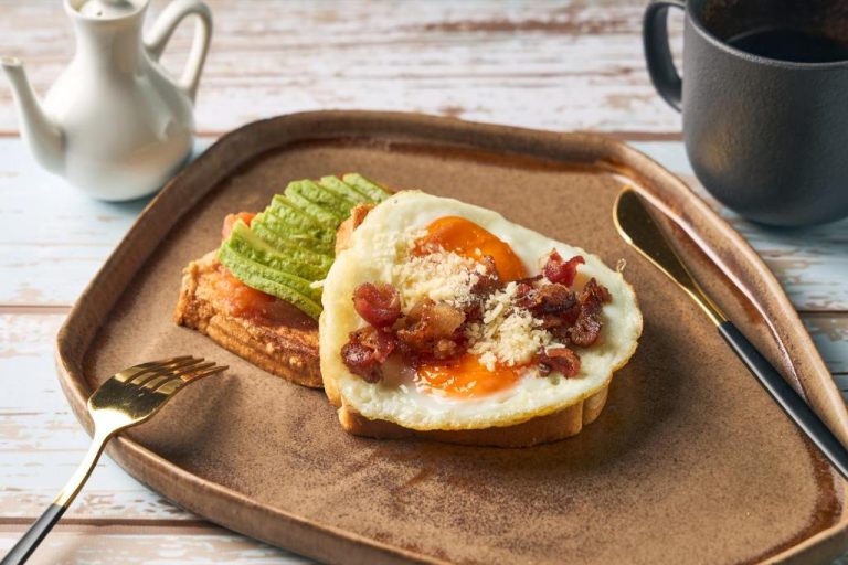 Desayuno del Iconik Hotel con tostada de aguacate, huevo frito, bacon y queso rallado