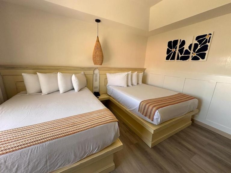Habitación doble con dos camas y decoración tropical en La Riviera Hotel