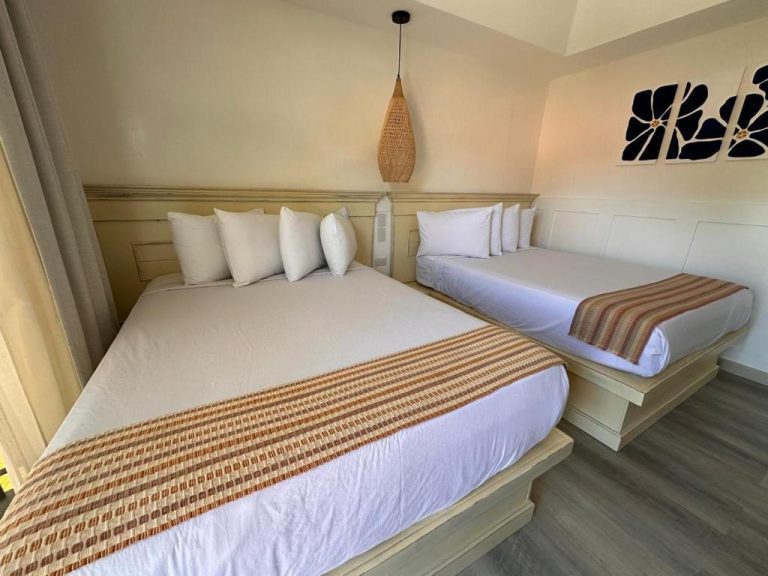 Habitación doble con dos camas y decoración tropical en La Riviera Hotel
