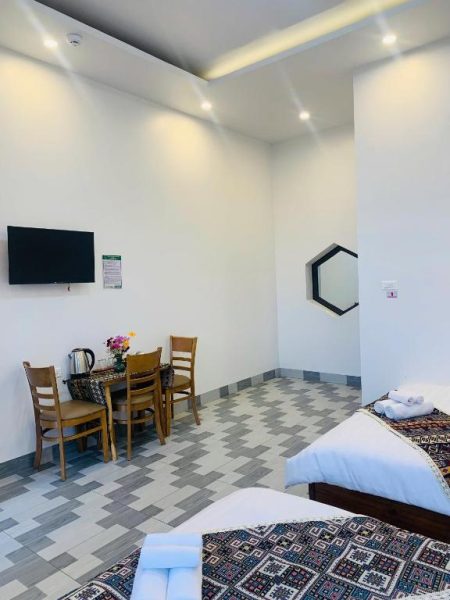 Habitación doble con camas, mesa de comedor y televisor del hotel MANG DEN Romantic