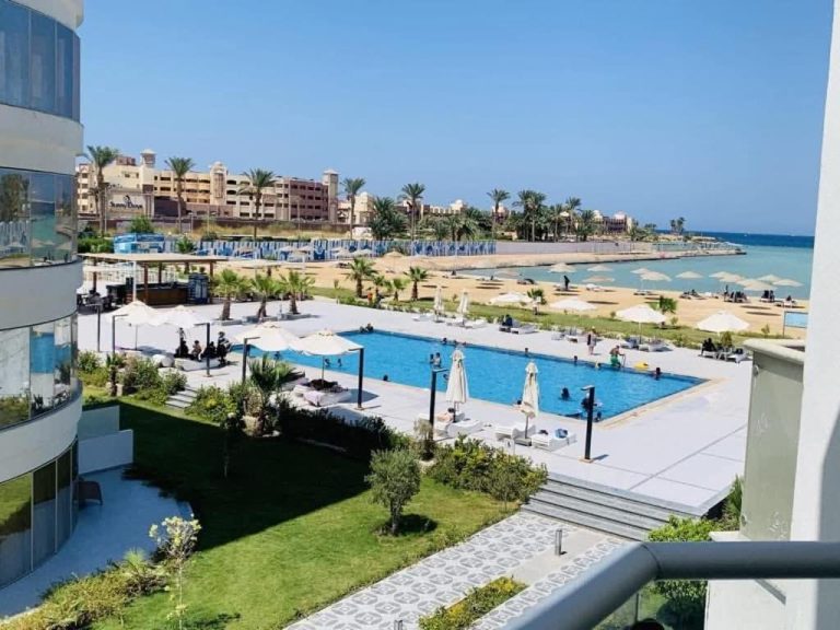 Piscina exterior con tumbonas y sombrillas en el Resort Scandic frente a la playa del Mar Rojo