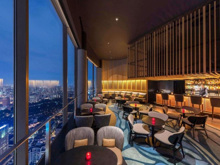 Bar panorámico en altura del Swissôtel The Stamford Singapore con vistas nocturnas al skyline de la ciudad