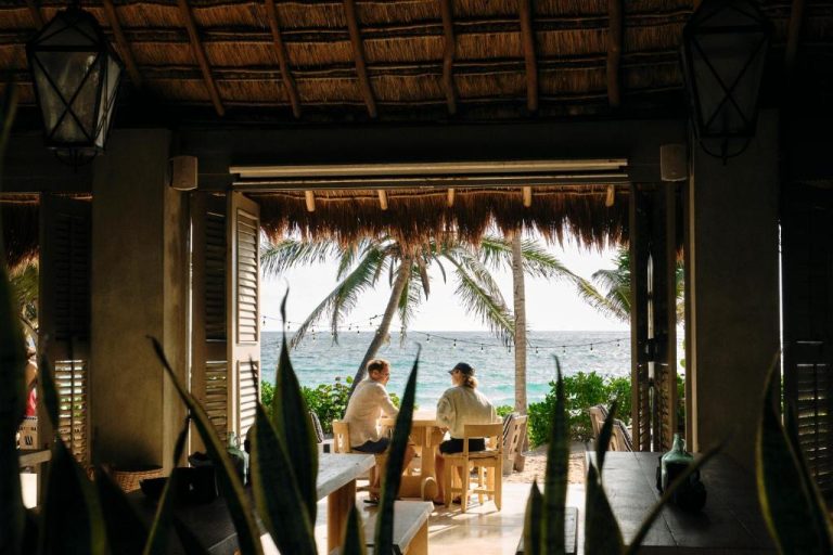 Pareja disfrutando del restaurante con vista al mar y palmeras en Hotel Panamera