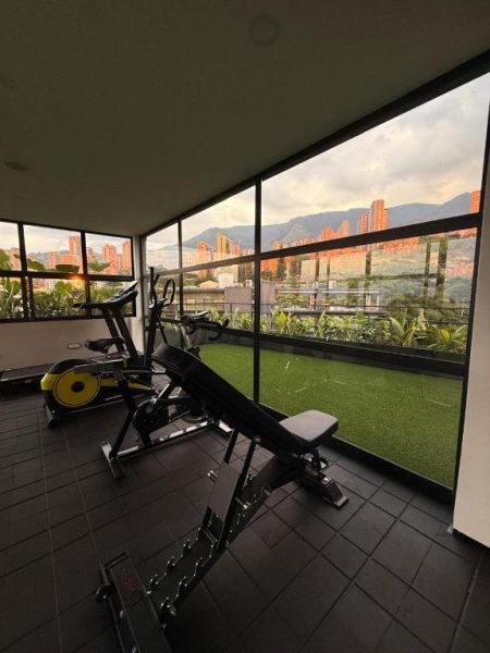 Gimnasio con bicicleta estática y banco de pesas en Lettera Hotel con vistas panorámicas a la ciudad