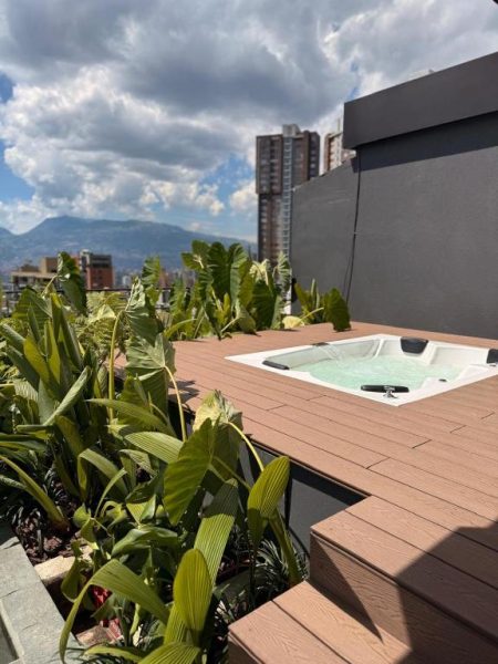 Jacuzzi en terraza exterior del Lettera Hotel con vistas a la ciudad y montañas al fondo