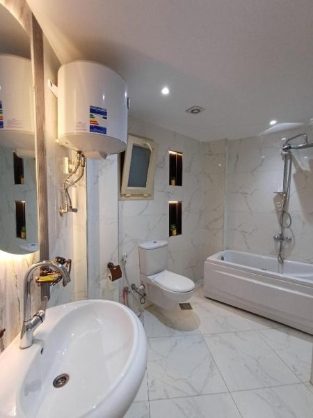 Baño completo con bañera, ducha y lavabo en mármol blanco del Lotus Hotel New Cairo