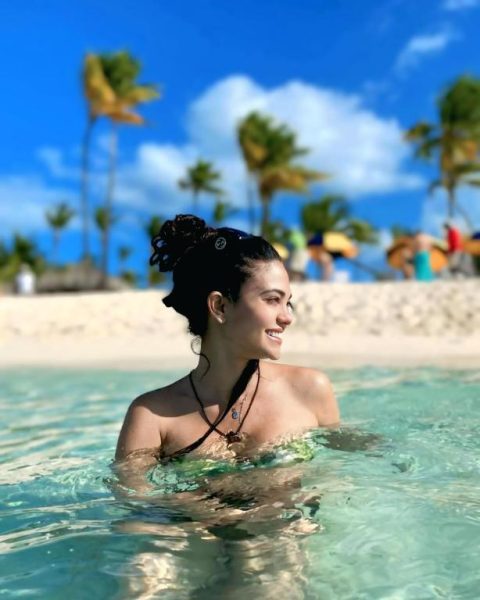 Mujer disfrutando del mar turquesa cristalino en la playa del Hotel Punta Cana Coral Beach Area I