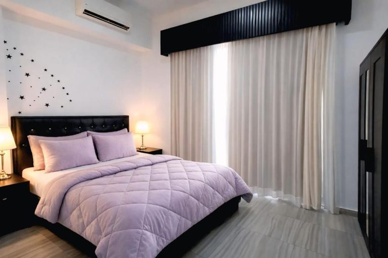 Habitación doble con cama matrimonial y decoración en tonos lila del Hotel Punta Cana Coral Beach Area I