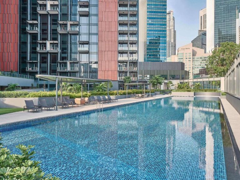 Piscina exterior con tumbonas y vistas a los rascacielos del Mercure ICON Singapore City Centre