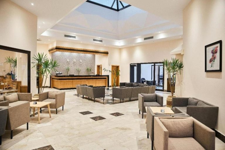 Amplio lobby con recepción y zona de descanso con sofás del Sky View Suites Hotel