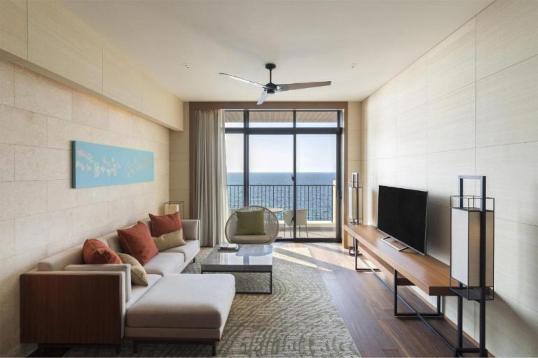 Salón con sofá, televisión y balcón con vistas al mar en Hyatt Regency Seragaki Island Okinawa