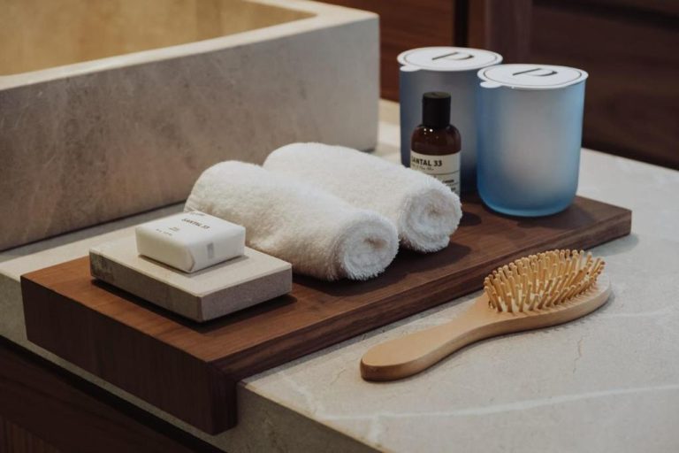 Amenities de baño de lujo del hotel Tuannaut con toallas, jabón Santal 33 y cepillo de madera